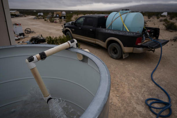 Water gushes into a homeowner's reservoir during a water delivery in 2024 in Terlingua. Most Texans rely on water from utilities. In some remote parts of the state, like Terlingua, residents have water delivered. The state's water supply is under duress from a number of threats including overuse and outdated infrastructure. Credit: Eli Hartman/The Texas Tribune