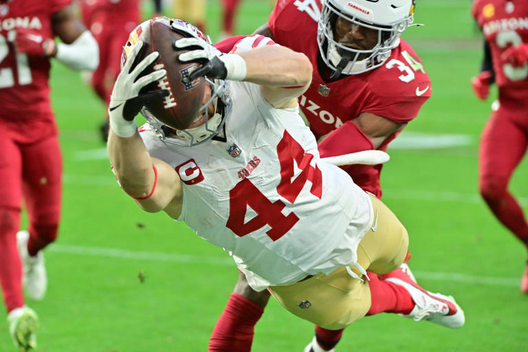 Jan 5, 2025; Glendale, Arizona, USA; San Francisco 49ers fullback Kyle Juszczyk (44) dives for a touchdown as Arizona Cardinals safety Jalen Thompson (34) defends in the second half at State Farm Stadium. Mandatory Credit: Matt Kartozian-Imagn Images