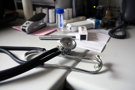 A doctor’s desk at a general practitioner’s surgery. UK.