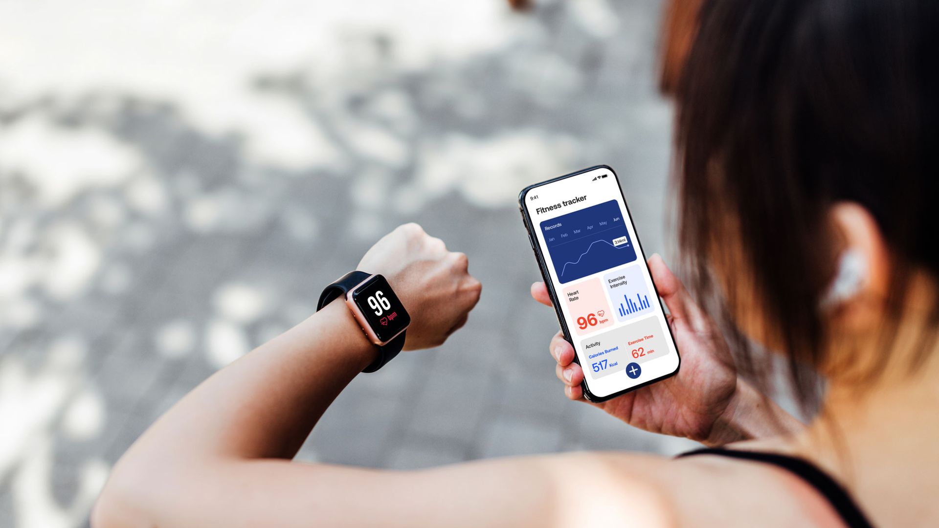 online health - a person wearing a smartwatch that displays a heart rate graph syncing to a tablet.