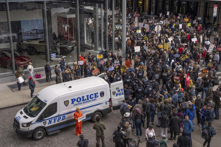 Demonstrators are arrested by NYPD officers while protesting Elon Musk and Tesla outside of a Tesla showroom on Saturday in New York.