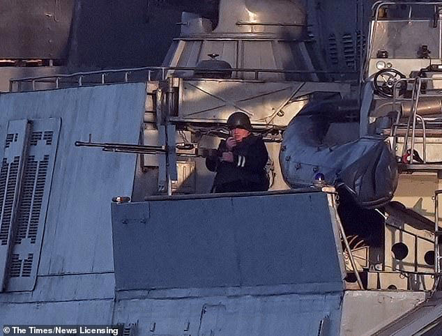 Russian officer brandishes machine gun on warship in the Channel