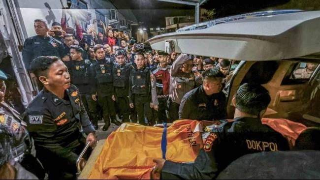 Petugas saat menurunkan jenazah anggota Polri yang tewas tertembak saat melakukan penggerebekan judi sabung ayam, setibanya di RS Bhayangkara Polda Lampung, Lampung, Selasa (18/3/2025).