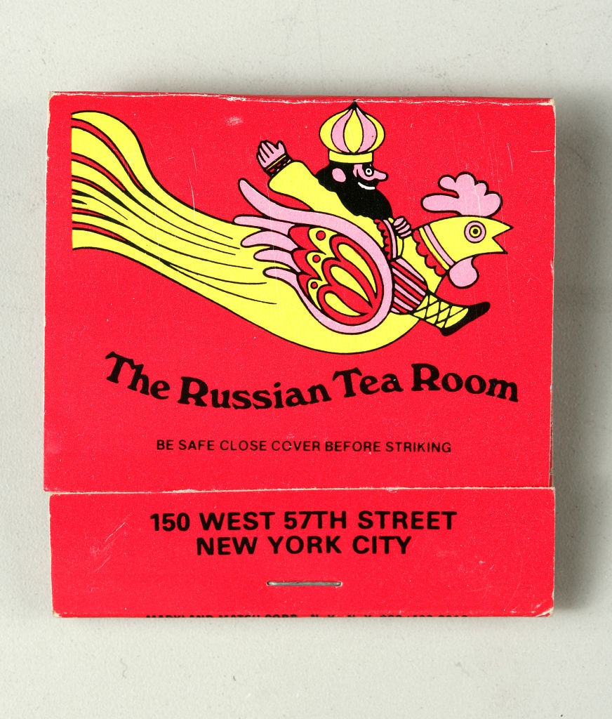 Matchbook cover for The Russian Tea Room in New York City with flying man and rooster illustration. Message: "Be safe—close cover before striking."