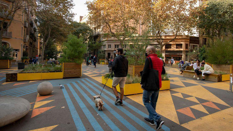 Pessoas caminham em uma área para pedestres, que faz parte do plano de superquadras em Barcelona