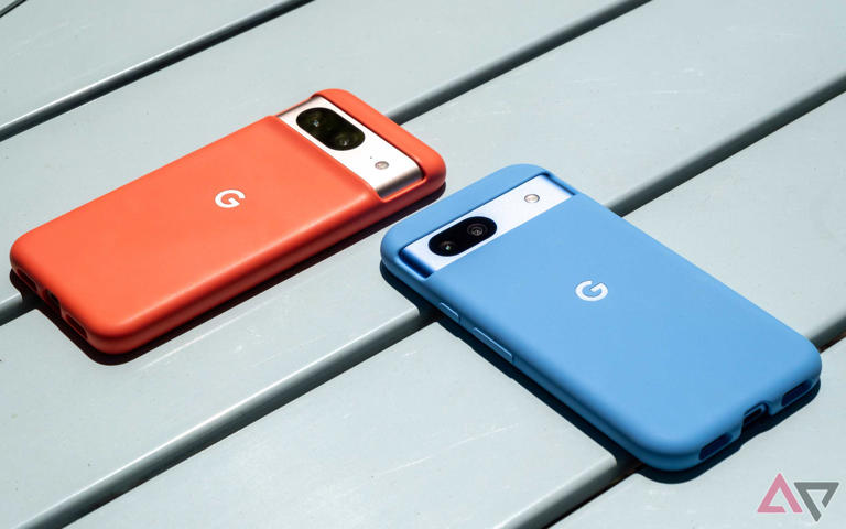 A blue smartphone and an orange smartphone on a metal table
