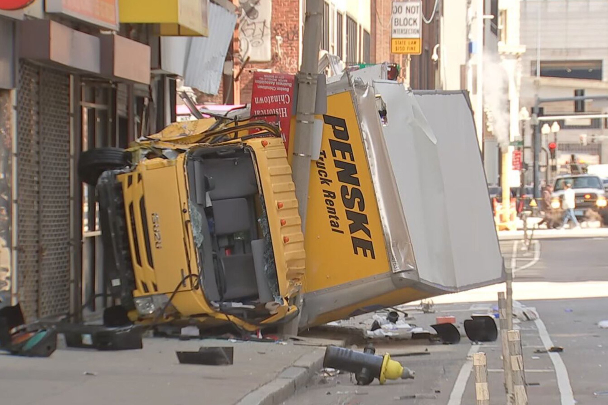 Truck in Boston flips sideways, crashes into busy sidewalk, injuring