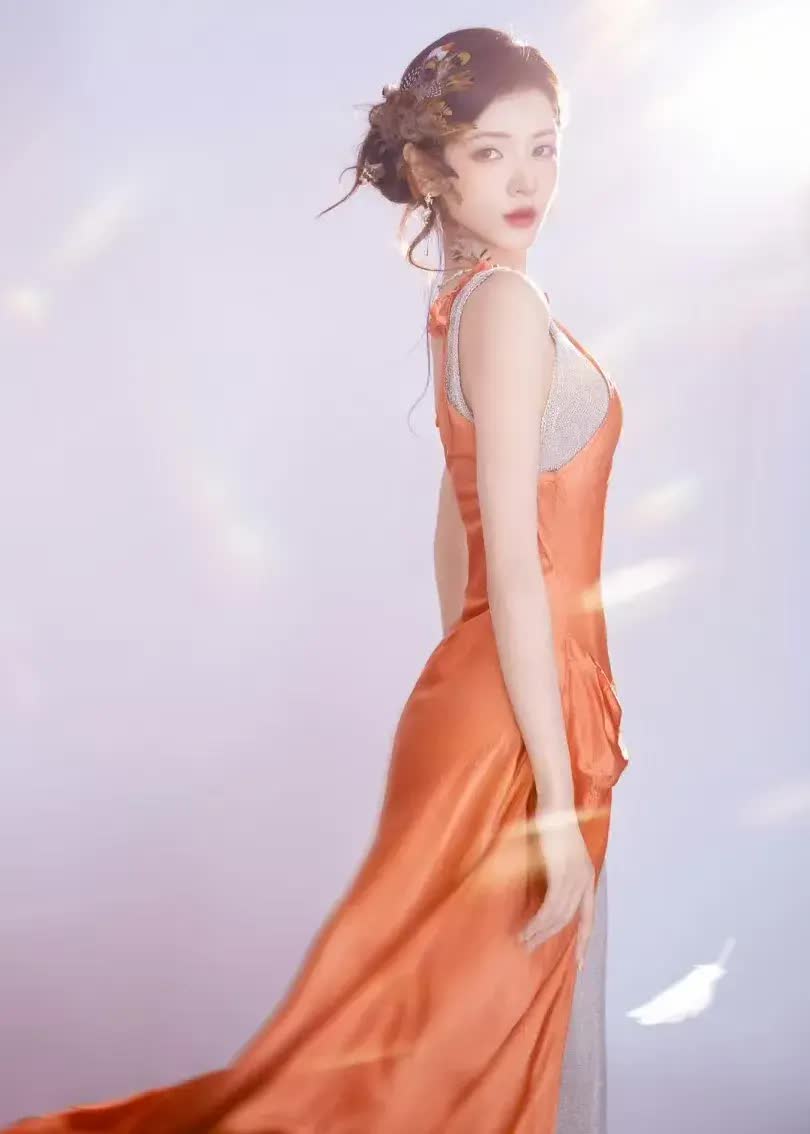 张予曦橙色吊带开叉裙亮相看片会，羽毛发饰氛围感拉满
