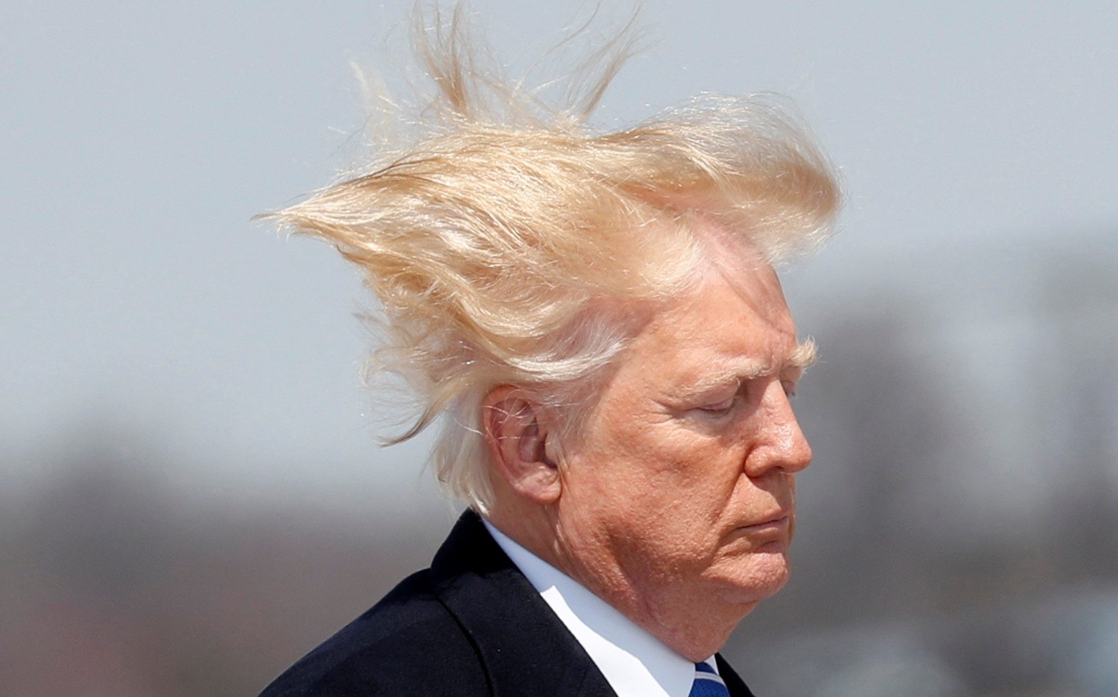 Mr Trump told reporters, ‘I like to take a nice shower, to take care of my beautiful hair,’ as he signed the order in the Oval Office on Wednesday - Kevin Lamarque/Reuters