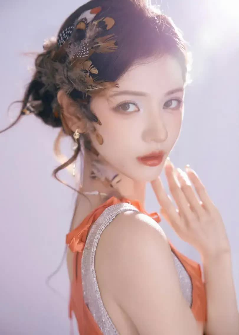 张予曦橙色吊带开叉裙亮相看片会，羽毛发饰氛围感拉满