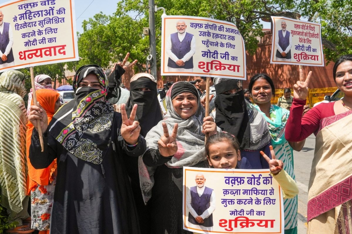 Members of Delhi BJP Minority Morcha flash victory sign as they celebrate after Union Minister of Minority Affairs Kiren Rijiju tabled the Waqf (Amendment) Bill in the Lok Sabha, near Parliament House, in New Delhi. (PTI Photo)