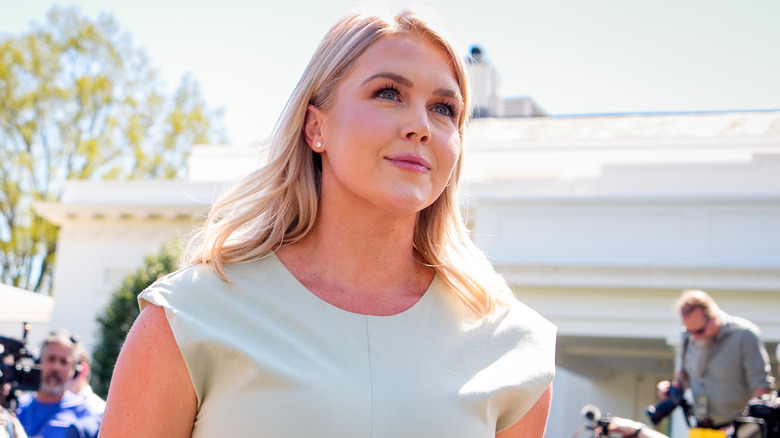 Karoline Leavitt walking amidst reporters