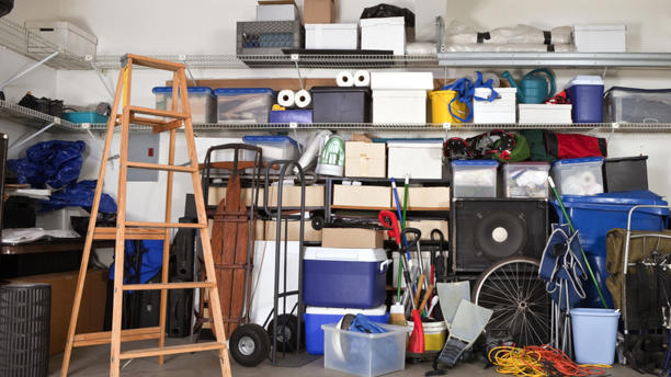 Disorganized garage with a ladder in it
