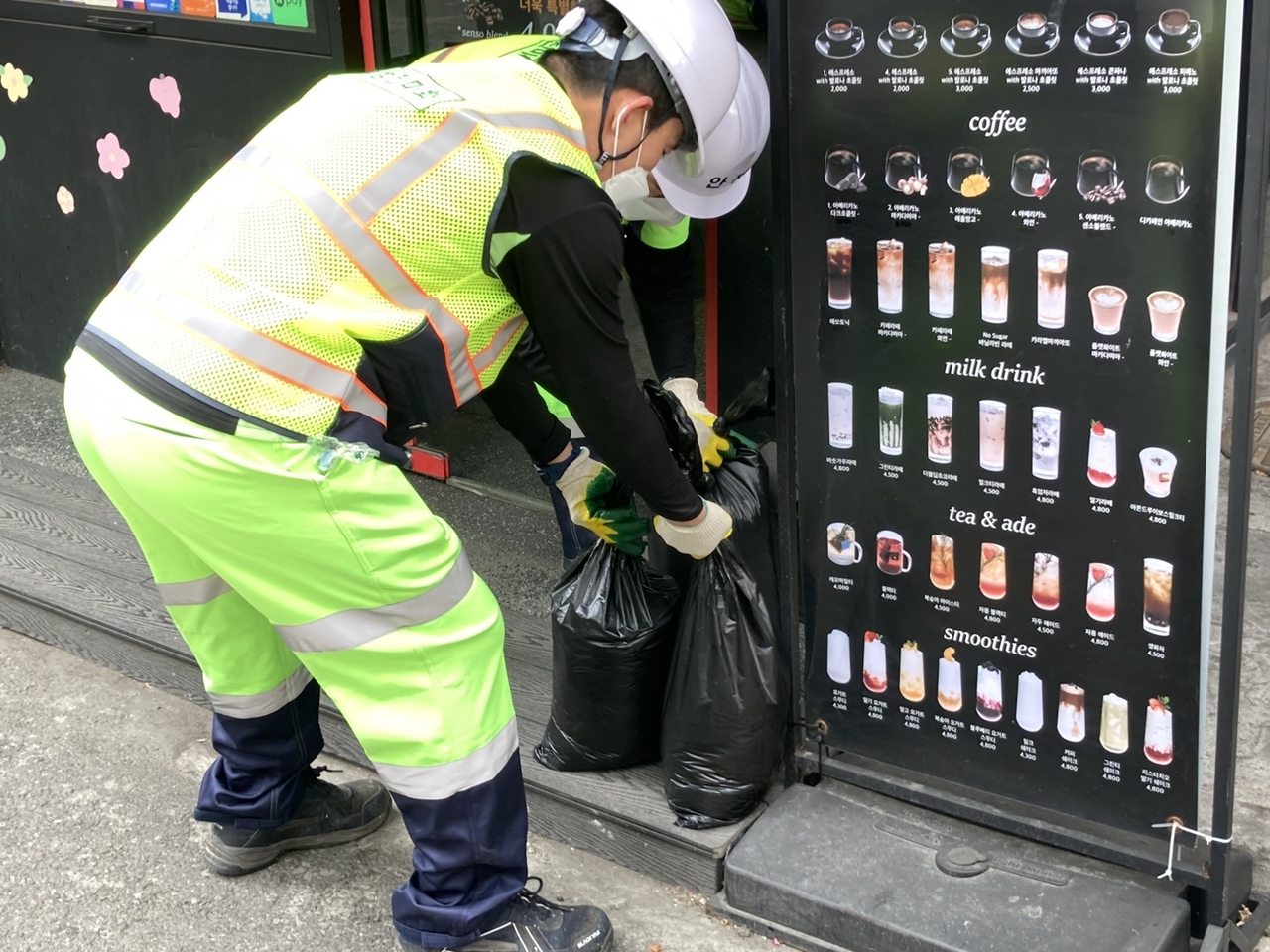 카페 앞에 놓인 커피찌꺼기 봉투를 환경미화원이 수거해 가고 있다. 손인규 기자