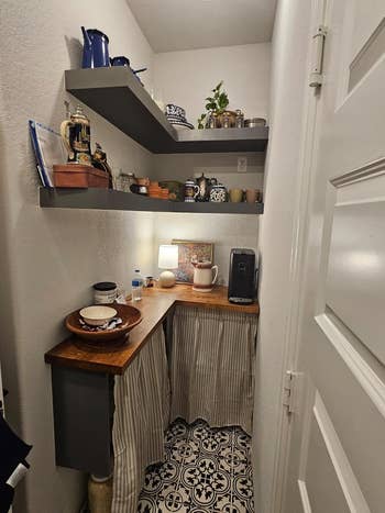 Small pantry nook with wooden countertop and striped curtains conceal lower storage