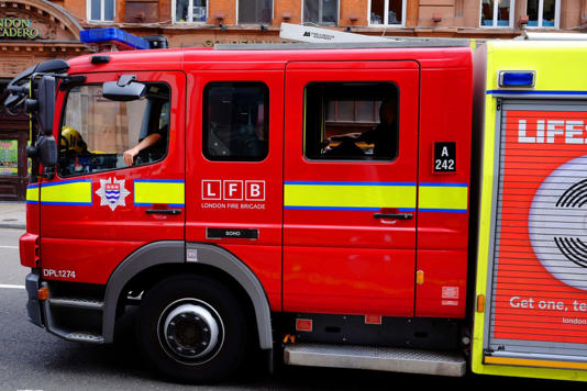 A fire engine of the London Fire Brigade returns along Shaftesbury Avene in London’s West End, to Soho Fire Station