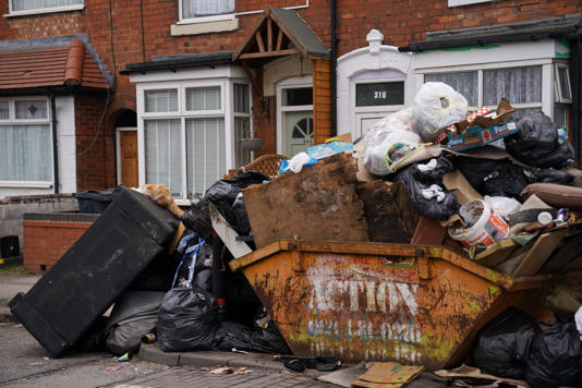 A cat rummaging through furniture and uncollected refuse bags in the Sparkhill area of Birmingham (Jacob King/PA)