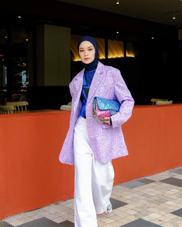 Gabungan outfit yang terdiri dari kemeja berwarna biru laut, blazer ungu muda, celana putih, jilbab biru laut, serta tas bahu dua warna Gabungan outfit yang terdiri dari kemeja berwarna biru laut, blazer ungu muda, celana putih, jilbab biru laut, serta tas bahu dua warna