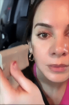 A reviewer is applying sunscreen with a contoured balm stick