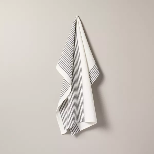 A white and grey stripped dish towel hanging on a small hook