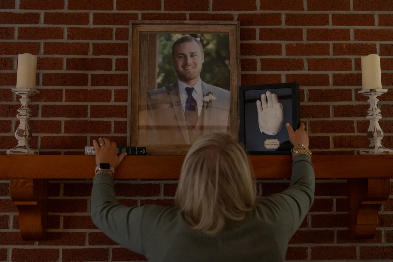 Jennifer Foley arranges a memorial to her brother, Scott Spivey, on the mantel of her parent’s home in Tabor City, N.C., on March 5, which would have been Spivey’s 35th birthday.