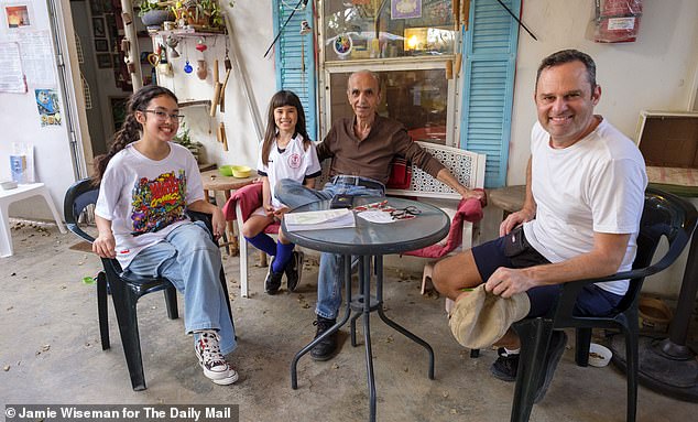 Pictured here in the community cafe he runs are 70 year old Rayek Rizek, a Christian Palestinian and one of the original members of the community, with 13 year old Ahava (left), her brother Sam and their father Eyal Raviv. They are some of the newest (Jewish) community members