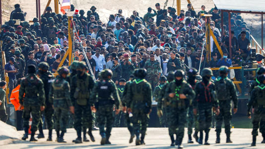 Victims of scam centres who were tricked or trafficked into working in Myanmar wait on a vessel. Pic: Reuters