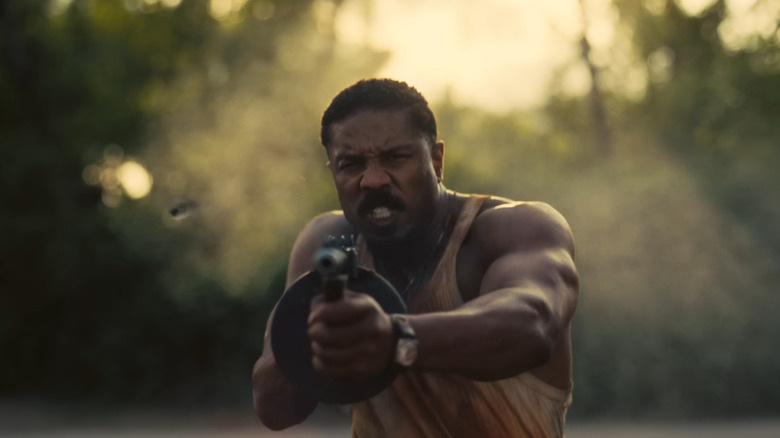 Michael B. Jordan as Smoke firing his tommy gun in Sinners