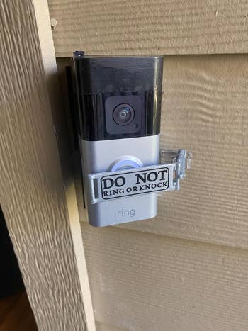 A doorbell camera with a sign that says,