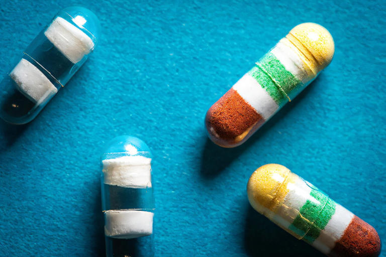 Medications in the capsules are separated by pH-responsive polymer barriers (white) that can be tuned to release each drug or dose at different times. This photo showcases capsules without medications (left) and those packed with medications (right). Credit: David Baillot/UC San Diego Jacobs School of Engineering