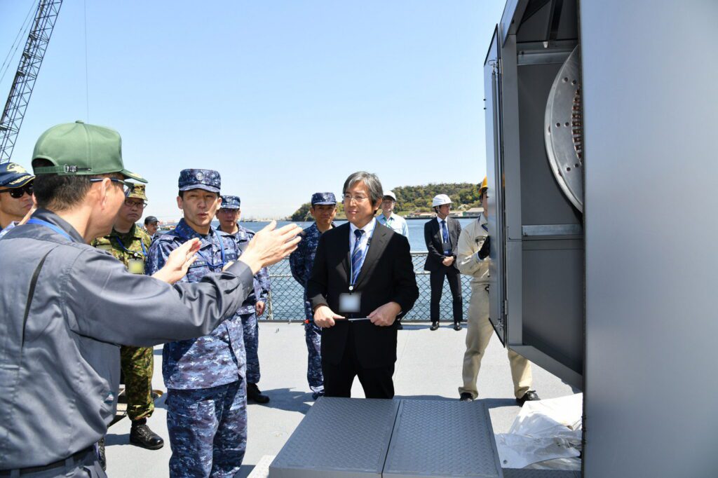 Vào ngày 9 tháng 4 năm 2025, Phó Đô đốc OMACHI Katsushi (trong bộ đồ màu xanh), Tư lệnh Hạm đội Phòng vệ (COMSDFLT), đã đến thăm tàu JS ASUKA, để quan sát tình trạng mới nhất của Railgun. (Pix qua SWNS)
