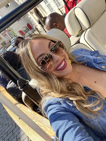Person taking a selfie in an open vehicle with curled hair