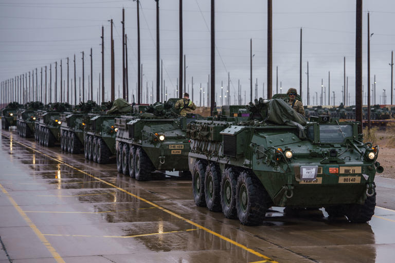 Soldados del Ejército de EE. UU. se preparan para trasladar vehículos blindados de transporte de infantería Stryker desde una estación de tren a un estacionamiento, donde estarán listos para desplegarse a lo largo de la frontera entre Estados Unidos y México como parte de la misión de la Fuerza de Tarea Conjunta de la Frontera Sur, en Fort Bliss en El Paso, Texas, el 5 de abril de 2025. (Foto de Paul Ratje para The Washington Post)