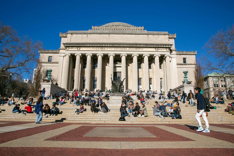 Estudiantes descansan en la escalinata de una biblioteca de la Universidad de Columbia en Nueva York.
