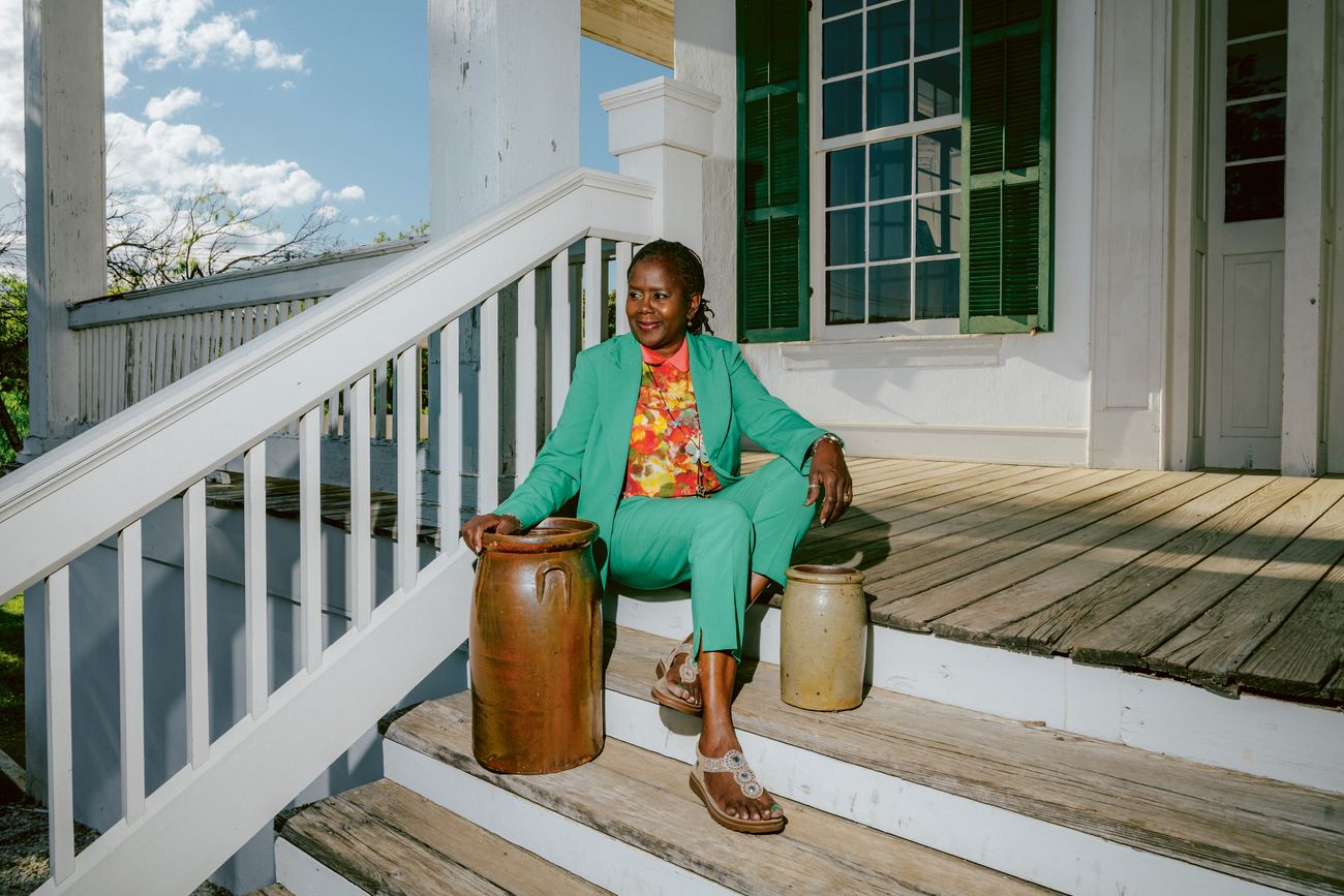 Paula King Harper a descendant of Hiram Wilson sits on the steps of the Sebastopol House in Seguin Texas with Wilson vessels from her own collection Harper leads the Wilson Pottery Foundation and coordinates the Wilson Pottery Show each October DeSean McClinton-Holland