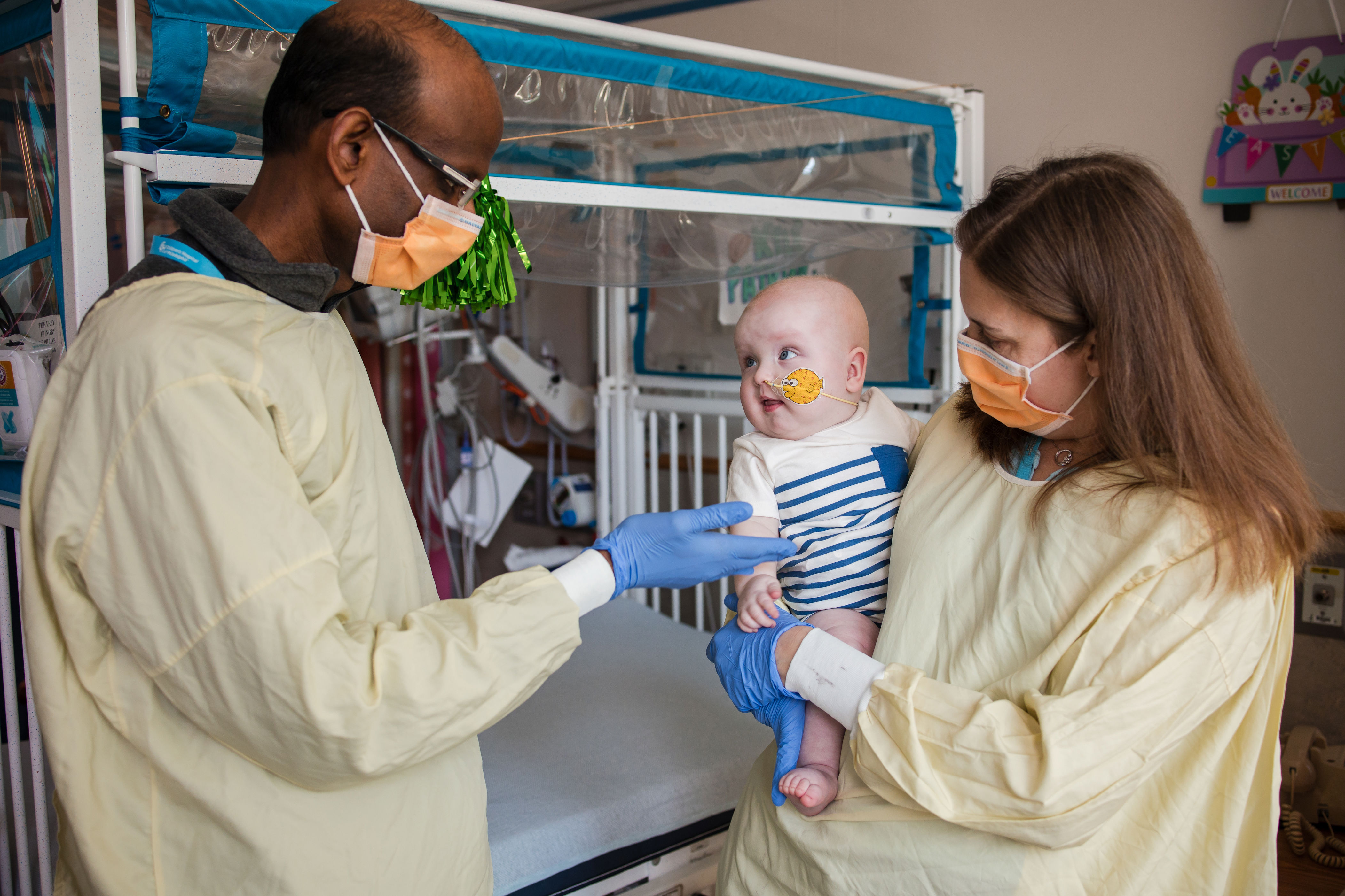 Cardiologist Kiran Musunuru and pediatric geneticist Rebecca Ahrens-Nicklas hold KJ Muldoon after he received an infusion of a drug custom-made for him.
