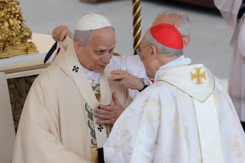 ▲教宗良十四世18日舉行就職彌撒，樞機主教為他披上象徵教宗的羊毛披帶。（圖／美聯社／達志影像）