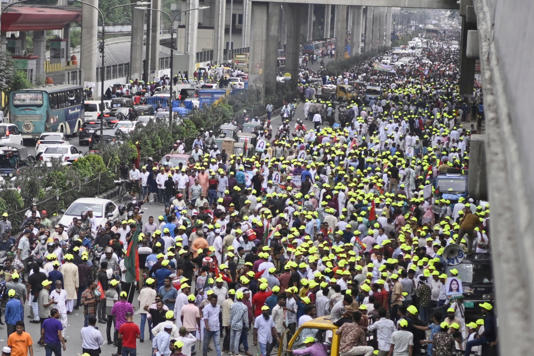 Supporters of Bangladesh's former prime minister Khaleda Zia march on a road as they welcome her arrival in Dhaka on 6 May 2025 (AP)