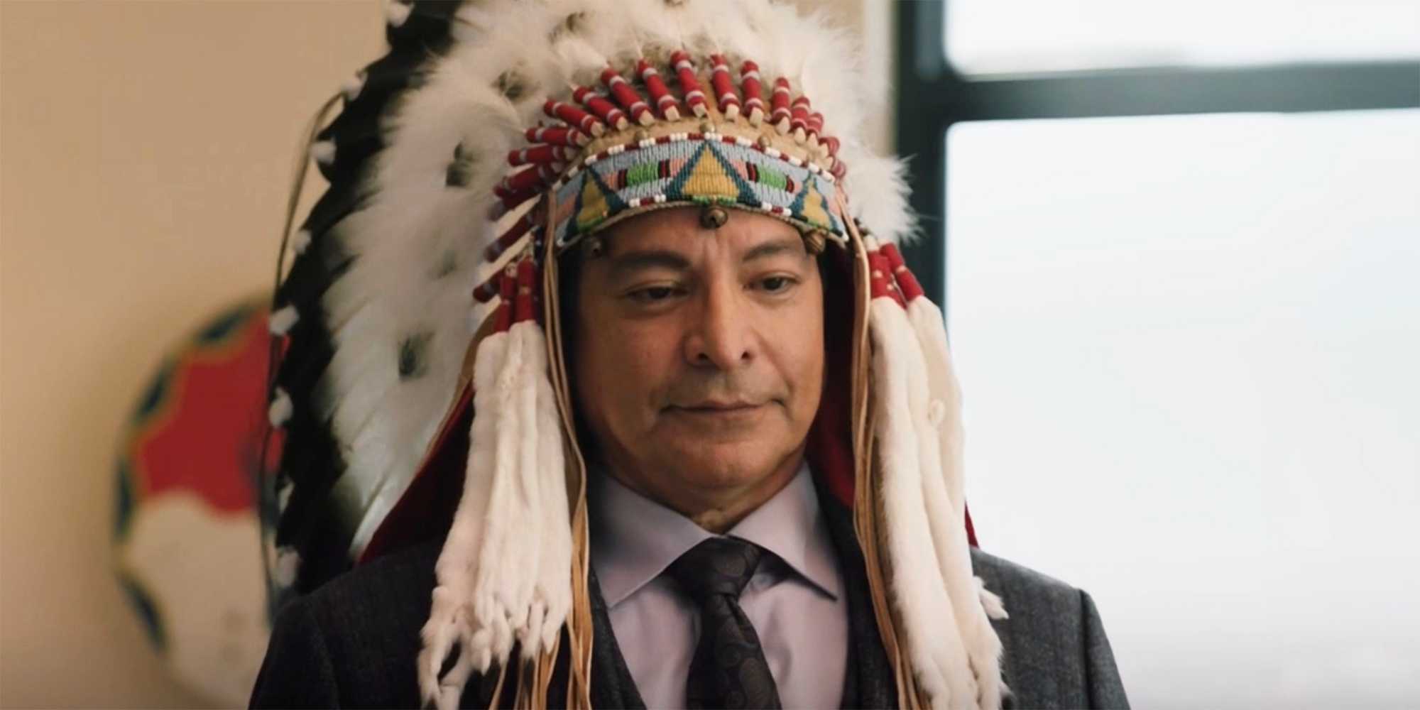 Thomas Rainwater adorned in a Native American headdress in Yellowstone