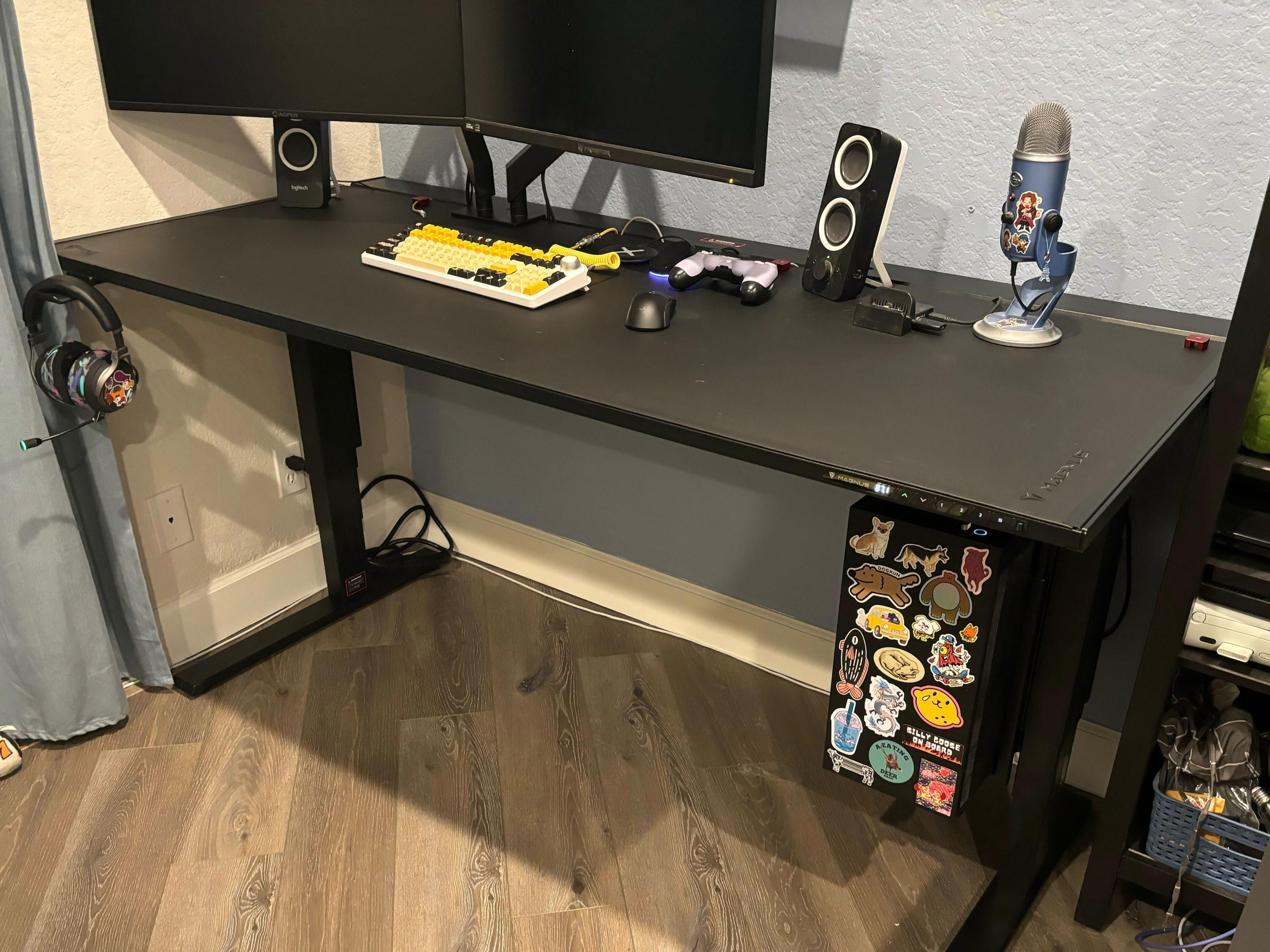 The Secretlab Magnus Pro desk shown with two monitors, a microphone and speakers, but no vsibile wires.