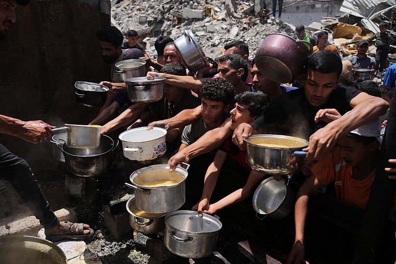 Un grupo de palestinos trata de conseguir alimentos donados en una cocina comunitaria en Jabalia, el 19 de mayo de 2025. AP