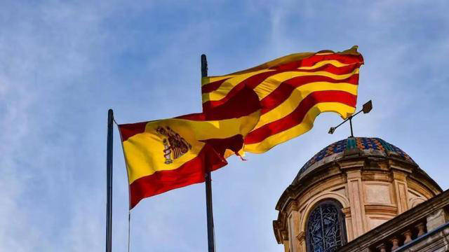 Una bandera española y una 'senyera' ondean al viento.