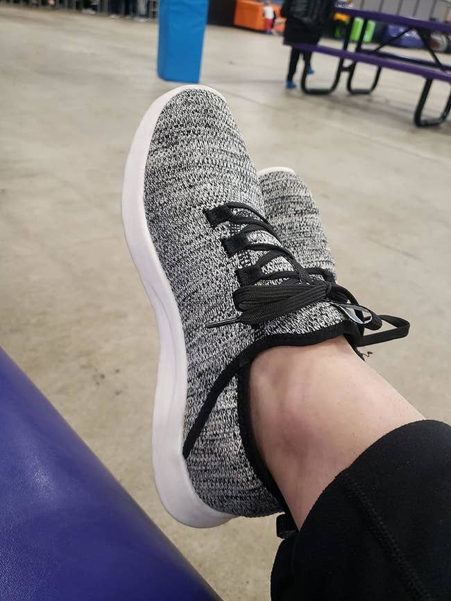 Reviewer's photo of their feet wearing the sneakers in the color Black Gray