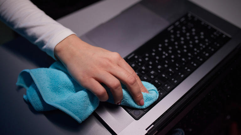 Person cleaning laptop