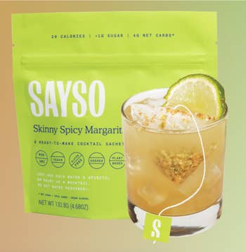 Sayso Skinny Spicy Margarita cocktail mix bag with a glass of margarita garnished with lime and rimmed with spice