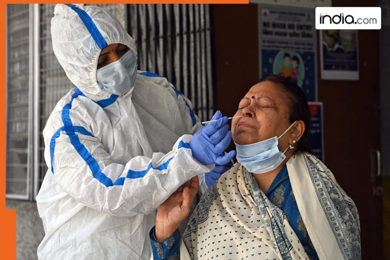 A health worker collects a nasal swab sample of a woman for the COVID-19 test amid a surge in cases, in New Delhi. (FILE ANI Photo)