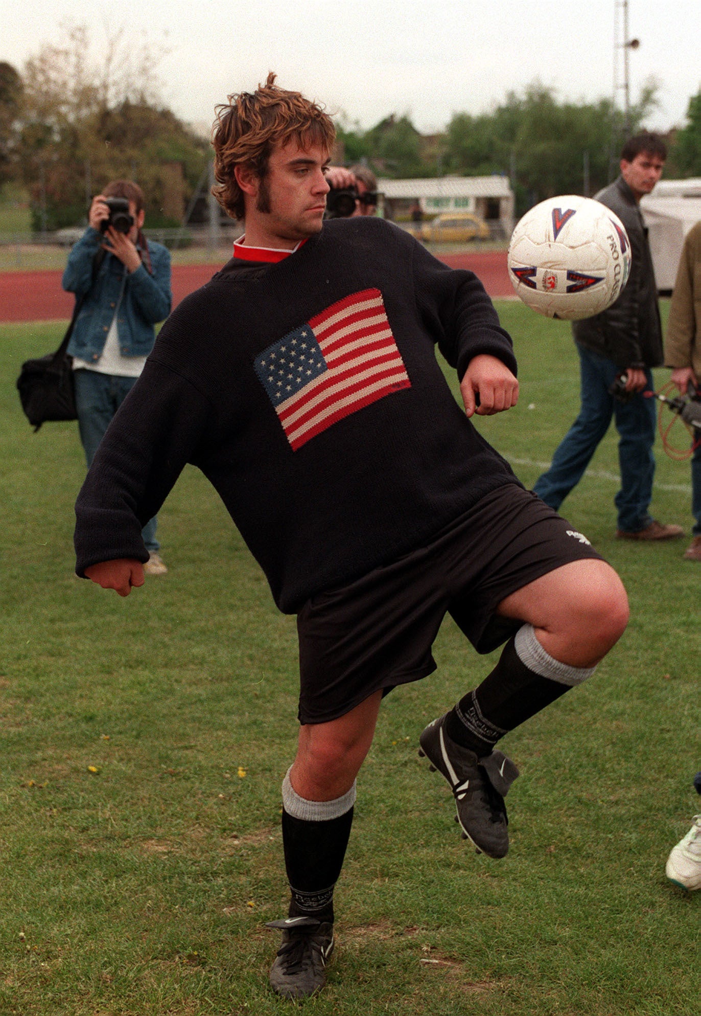 Robbie Williams playing football in 1996 (David Cheskin/PA)