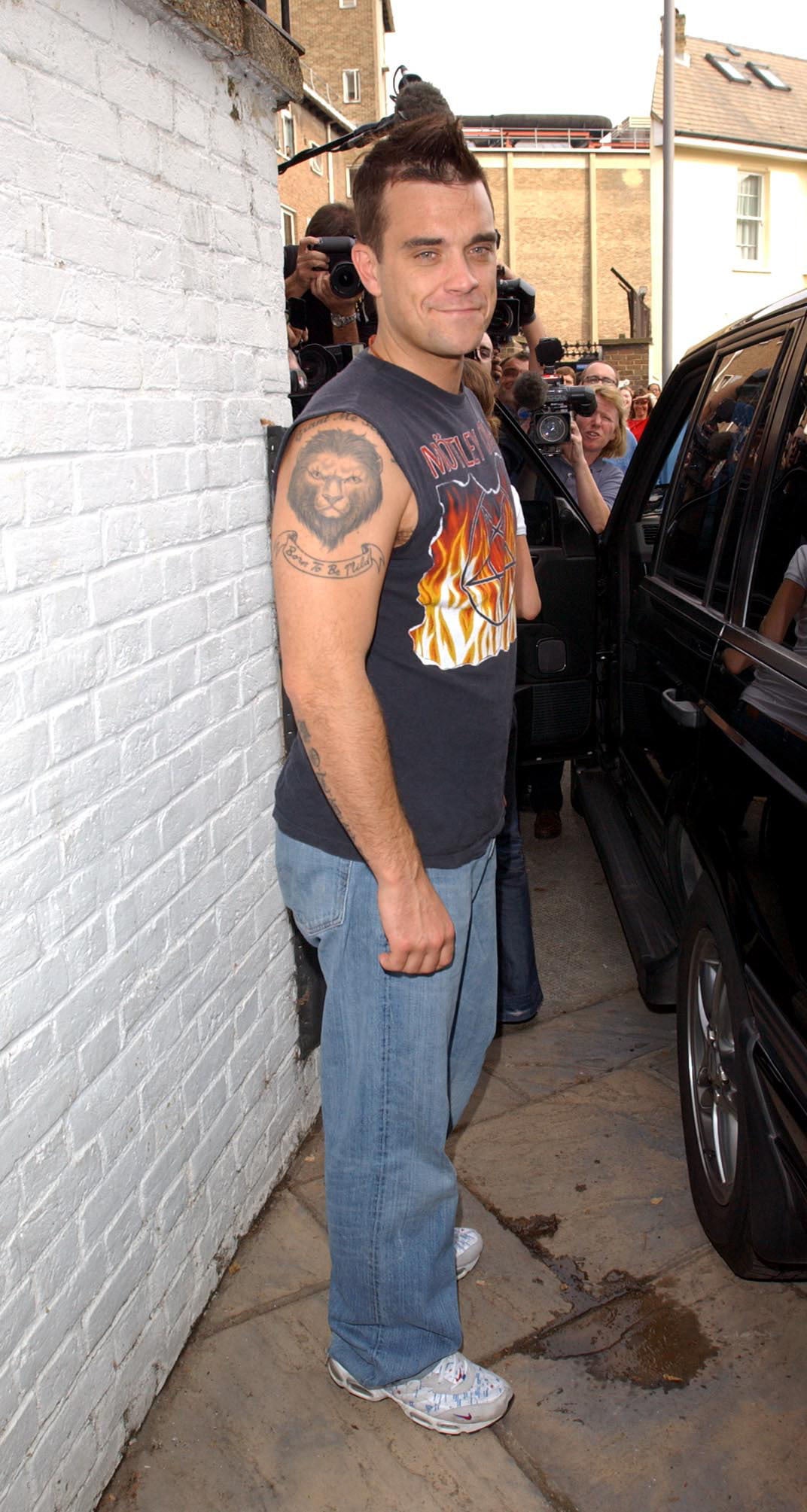 Robbie Williams leaving his management company in west London, 2002 (Ian West/PA)