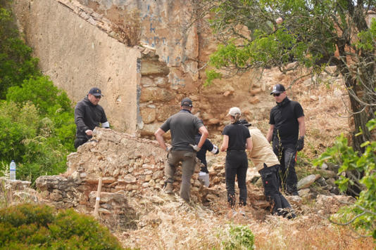 Search teams look through a derelict and abandoned property to the west of Praia De Luz, Portugal on Tuesday (James Manning/PA Wire)
