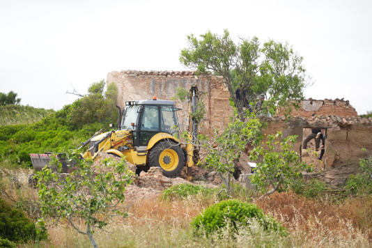 A digger being used to move rubble (PA)